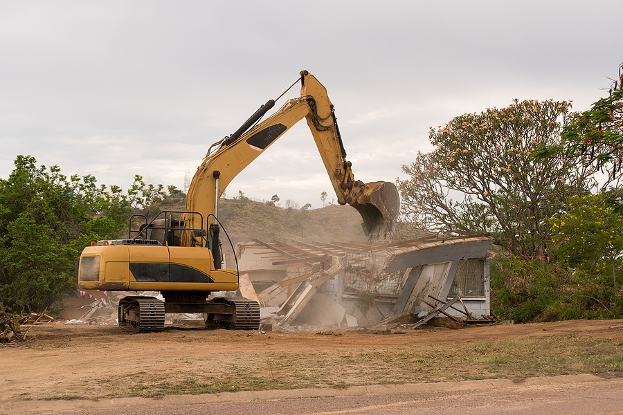 Bulldozer knocking down old house to rebuild