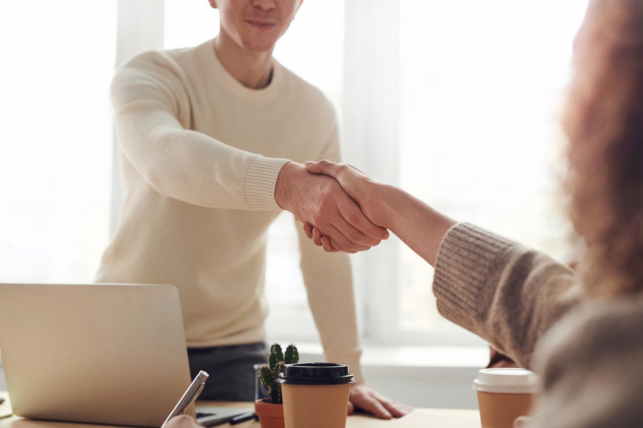 Mortgage lender and new home owner shaking hands