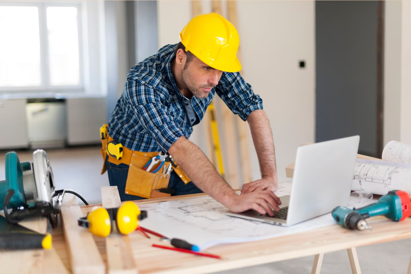 home builder examining plans on computer